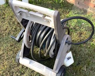 3 water hose reels. Two have hoses attached.