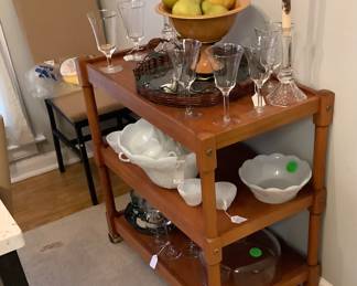 Serving cart in breakfast room. Several crystal pieces on green tray with vines. Also has pieces of milk glass like punch bowl and serving bowl.