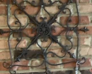 Metal wall hanging in sunroom.