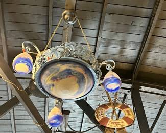 Unusual antique hanging light fixture featuring a central painted dome shade suspended by chains, surrounded by four smaller glass globe lights with blue-accented detailing. The piece blends decorative metalwork and art glass for a whimsical, early 20th-century look. Strong visual impact with age-appropriate wear and patina. Ideal for collectors or statement lighting. All items sold as-is.