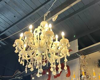 Elegant Schonbek crystal chandelier featuring cascading faceted prisms, scrolling crystal arms, and candle-style lights. Renowned for exceptional craftsmanship and brilliance, this chandelier offers timeless luxury and dramatic sparkle. Ideal for refined interiors or statement lighting. Condition consistent with age. All items sold as-is.