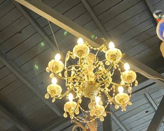 Unusual antique hanging light fixture featuring a central painted dome shade suspended by chains, surrounded by four smaller glass globe lights with blue-accented detailing. The piece blends decorative metalwork and art glass for a whimsical, early 20th-century look. Strong visual impact with age-appropriate wear and patina. Ideal for collectors or statement lighting. All items sold as-is.