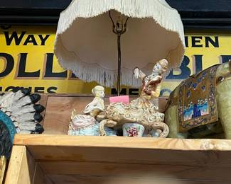 Charming vintage table lamp with a scalloped fabric shade trimmed in fringe, paired with a porcelain figural base featuring classical-style cherubs and decorative detailing. Soft, romantic character with age-appropriate wear and patina. Ideal for traditional interiors, collectors, or accent lighting. All items sold as-is.