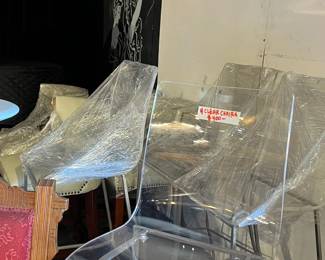 Set of modern clear acrylic chairs with molded seats and minimalist design. Lightweight and visually striking, suitable for contemporary interiors or display use. Chairs show light wear from storage and handling. Ideal for dining, accent seating, or staging. All items sold as-is.