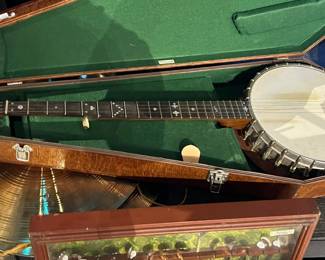 Vintage banjo housed in a fitted hard case with green felt interior. Features classic metal-rim construction and wooden neck with inlay detailing. Shows age-appropriate wear and patina consistent with use and storage. Ideal for musicians, collectors, or decorative display. Functionality untested. All items sold as-is.