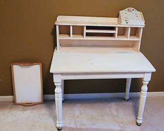 Farmhouse Slant-Front Writing Desk – Solid Wood, Sturdy, Needs Paint Refresh: Charming farmhouse-style slant-front writing desk, painted white with classic country character. This piece is solid wood, well-built, and very sturdy—perfect for a small home office, entryway, bedroom workstation, or creative space. The slanted drop-front opens to reveal cubbies and writing space, while the lower drawers add extra storage. The desk does need a fresh coat of paint, making it an ideal project for someone who loves DIY or shabby-chic transformations. A beautiful piece with great potential!