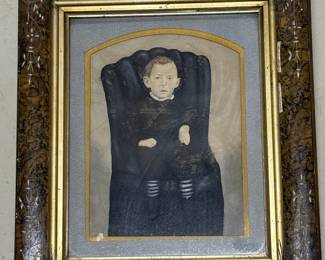 Picture of boy on a black chair. Ornate frame. Price $120