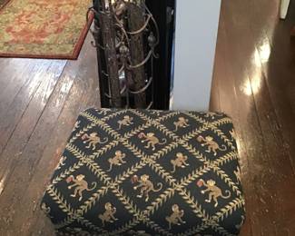 footstool with an elephant design cushion and metal ornate wine rack