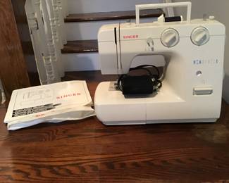 Singer sewing machine with paperwork and cover