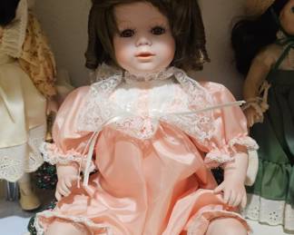 A collectible porcelain doll with a pink satin dress, likely from 2001.