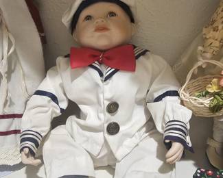 A Yolanda Bello "Matthew" porcelain baby doll in a sailor outfit.