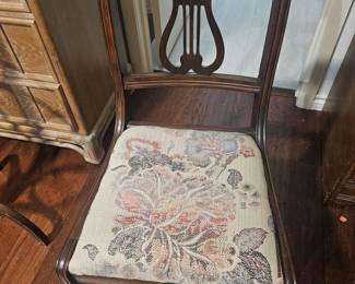 vintage wooden lyre-back chair with tapestry upholstery.