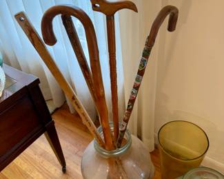 Vintage walking sticks and canes and tall vases. 