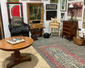 Art work of all sizes and styles, Black wicker chair, round wood pedestal coffee table