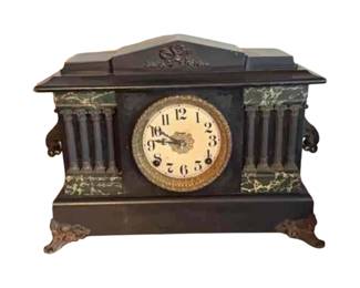 Antique ebonized wood mantle clock with marbleized columns. Circa 1900 to 1910.