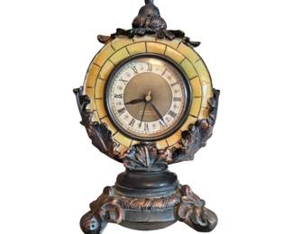 Ornate decorative mantle clock with Roman numerals and scrolled base.