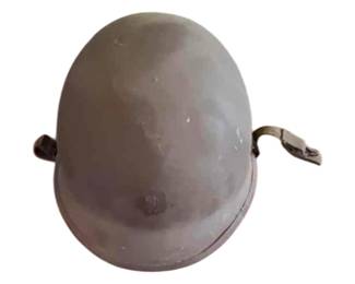 US M1C steel combat helmet with a canvas chin strap . Circa mid-20th century.