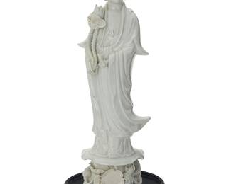 3149
A Chinese Dehua-style porcelain figure of Guanyin
20th century
Depicted with a lotus flower slung against right shoulder, the left hand loosely mounted, raised on a lotus pad pedestal mounted with lotus flowers and pads in high relief, set on a hardwood stand
Porcelain: 20.75" H x 6.5" W x 6" D; Stand: 2.25" H x 10" Dia.
Estimate: $200 - $400