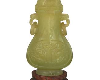 3164
A Chinese carved jade lidded vessel
20th century
Carved with Taotie mask to body, featuring opposed handles with ring accents and a floriform finial, set on a hardwood stand
Jade: 6" H x 3" W x 1.875" D; With stand: 7.25" H
Estimate: $500 - $700