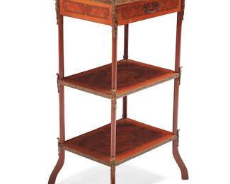 3080
A French marquetry étagère
20th century
The wood display stand with single drawer above two undershelves, each with marquetry veneer decoration, featuring gilt-metal mask and foliate mounts, upper pierced gallery, drawer pull, and trimming
32.5" H x 18.25" W x 15" D
Estimate: $300 - $500