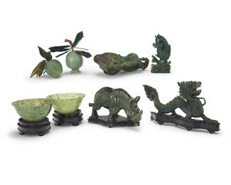 3171
A group of Chinese hardstone carvings
20th century or earlier
Comprising a nephrite dragon, a nephrite rhinoceros, a nephrite fish, two carved jade fruits with pliable string-wrapped branches and nephrite leaves, a nephrite lily pad dish, and two jade bowls, the figures and bowls set on wood stands
8 pieces
Each bowl: 2.125" H x 5" Dia.: Dragon: 4.625" H x 10.5" W x 1.5" D
Estimate: $200 - $400