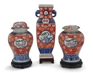 3221
An assembled Japanese Arita ware porcelain garniture
20th century
Each bearing an apocryphal reign mark for Chenghua Period (1465-1487)
Comprising a squared vase with opposed figural handles and a near-pair of lidded jars, each set on a hardwood stand
3 pieces
Vase: 12.5" H x 5" W x 4.625" D; Taller jar: 8.875" H x 5.75" Dia.
Estimate: $200 - $300