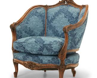 3081
A Louis XV-style carved walnut bergère
Early 20th century
With elaborately carved crest rail floral element and front apron, bellflower motifs to armrests, and scrolled feet, upholstered front and back in a textured blue floral fabric
37.5" H x 34.25" W x 30" D
Estimate: $200 - $300