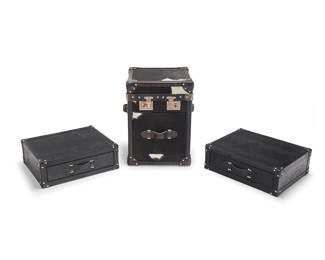 3351
A collection of Contemporary cowhide and faux leather cabinets
Late 20th/early 21st century
Largest marked to latch hardware: Bond St. / London; with 'bowler hat' metal logo to interior
Comprising a Bond St. London black and white hair-on-hide cowhide tall rectangular chest cabinet with latched top lid revealing a shallow upper compartment above a drawer to lower front, trimmed in leather and with silver-toned metal hardware and leather handles to three sides (22.5" H x 16" W x 16" D; 19" including handles), as well as two black alligator faux leather-covered suitcase-style stackable drawer cabinets, each with silver-toned hardware (Each: 6.5" H x 20" W x 16" D)
3 pieces
Estimate: $200 - $300