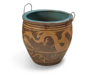 3260
An East Asian ceramic jardinière
19th century or later; China or Southeast Asia
The jardinière depicting a dragon figure in ochre and brown glazes, with a teal glazed interior, the rim fitted with a metal ring and opposed handles
Without handles: 19.75" H x 20.5" Dia.
Estimate: $300 - $400