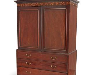 3089
A George III Chippendale-style mahogany linen press
19th century with later elements
The broken swan neck and latticework pediment above denticulated trim and a band of fretwork, above two hinged locking cabinet doors revealing an updated interior of five drawers, above three more long locking drawers with brass pulls, raised on bracket feet
85.5" H x 52.5" W x 24.75" D
Estimate: $600 - $800