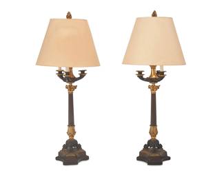 3077
A pair of Empire-style gilt and patinated bronze table lamps
Early 20th century
Shades stamped: Artemis Studios
Each in the form of a Classical oil lamp raised on a fluted columnar standard with foliate capital, raised on scroll legs on an architectural tripartite base, surmounted by a paper conical shade and flame finial, electrified
2 pieces
Each base: 38" H x 8.5" W x 8" D; Each shade: 11.5" H x 16.25" Dia.
Estimate: $300 - $500