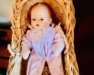Baby doll in wicker baby bay basket