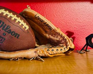 Wilson football and leather baseball glove, metal sculpture
