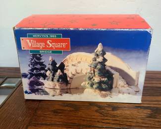 This is a Mervyn's Village Square Cobblestone Bridge, a vintage Christmas village accessory. 
It is part of the "Village Square" collection by Mervyn's. 
The piece is made of ceramic and porcelain. 