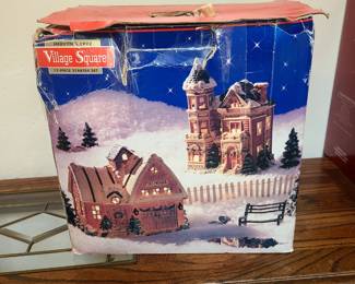 This is a Mervyn's 1992 Village Square 12-piece starter set. 
The set is a vintage collectible Christmas village item. 
The box features illustrations of a fire house and a school building. 
The pieces are typ