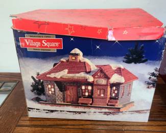This is a Mervyn's Village Square Train Station collectible. 
It is a lighted Christmas village building from Mervyn's Village Square collection, dated 1992. 
The piece is crafted from porcelain and features a deta