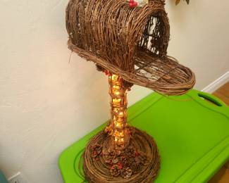 This is a vintage lighted mailbox made of grapevine material with natural pine cones and red berries. 
It features a wire frame and is designed to light up.
The item is freestanding, suitable for seasonal or holiday decor.