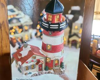 This is a Santa's Workbench Collection Bayside Lighthouse, a lighted porcelain collectible for a Christmas village display. 