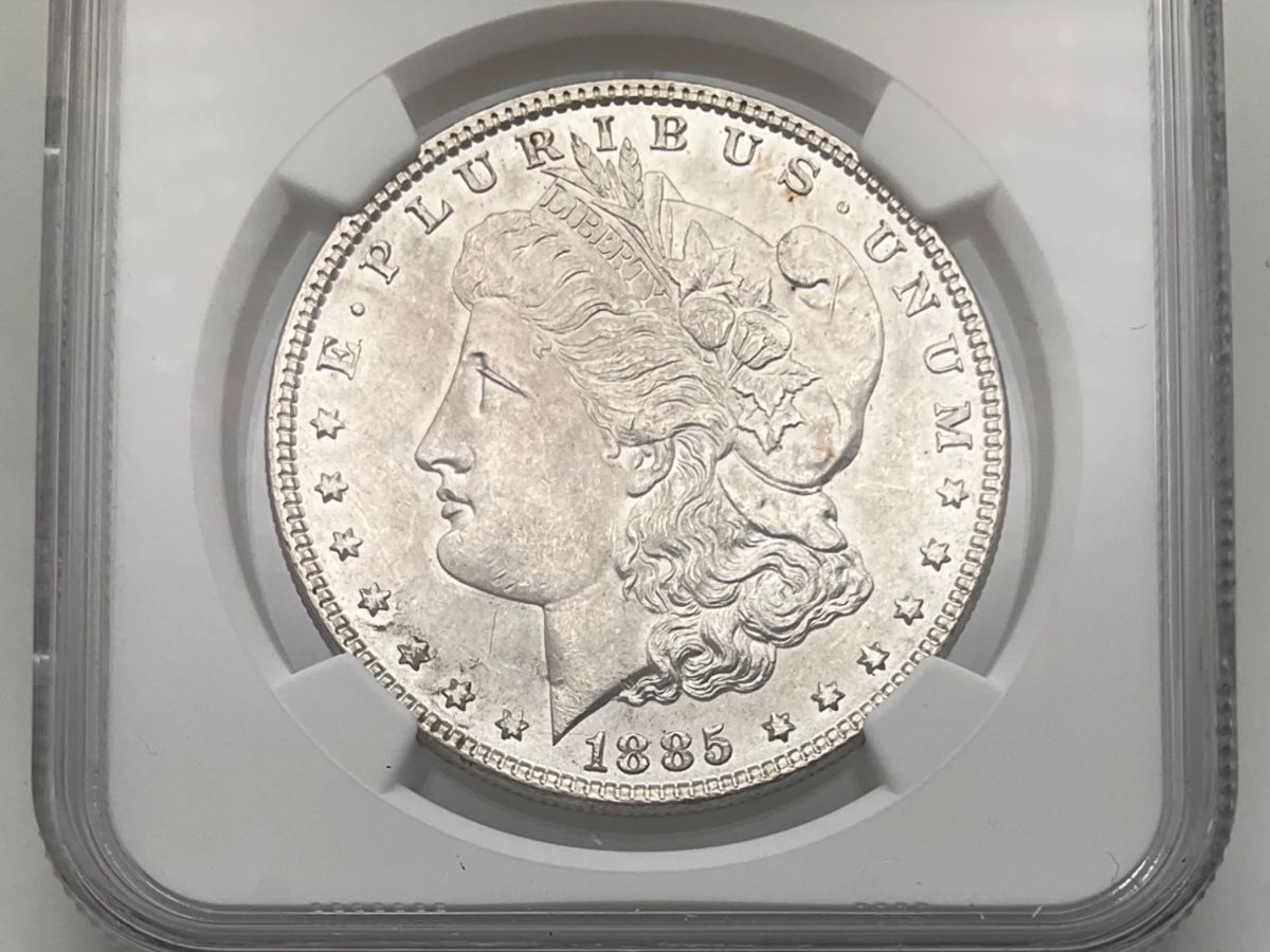 1885 Morgan Dollar, graded MS 63 by the Numismatic Guaranty Company.