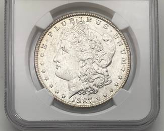 1887 Morgan Dollar, graded MS 62 by Numismatic Guaranty Company.