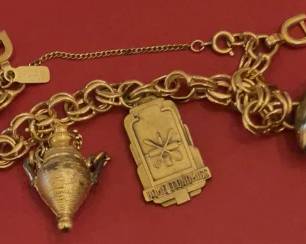 Vintage Monet gold tone charm bracelet with perfume urn