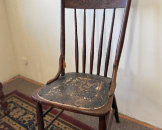 Antique pressed-back dining chair with a distressed finish and decorative seat pad
