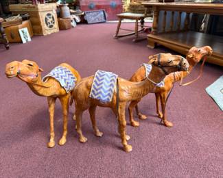 Vintage leather-wrapped dromedary camel figurines featuring harnesses and decorative saddles
