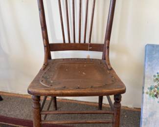 Antique hight back with decorative “Pressed” design and turned spindles and leather seat
