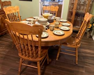 Solid oak dining table with one extension leaf and six press-back chairs