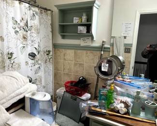 Bathroom items, towels, humidifier, scales, curling irons, lighted magnifier mirror, green wall shelf and misc bathroom items