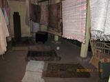 Many different antique rugs hung and clothes lines,