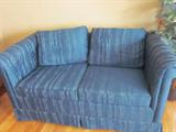 Dark green love seat, matching dark green sofa.
