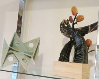 On the left is an unsigned Modernist ceramic. On the right is a carved horn bird sculpture from Big Sun in Austin, Texas