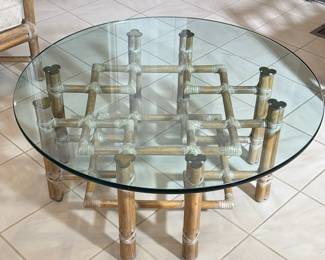 McGUIRE RATTAN, RAWHIDE & GLASS LOW TABLE, ORGANIC MID CENTURY | Low table designed as a round glass top resting on a woven wood / bamboo style base with brass mounts
Dimensions: h. 17 x dia. 40 in
